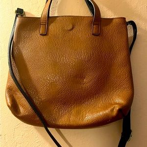 Tan leather bag with black interior and long crossbody strap